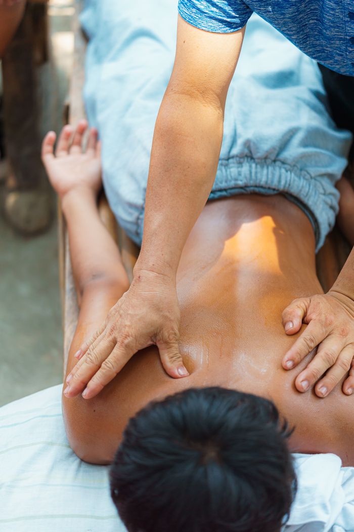 Relaxing outdoor back massage with an expert masseuse applying gentle pressure for muscle relief.